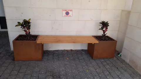שתי אדניות קורטן ומושב עץ ביניהן